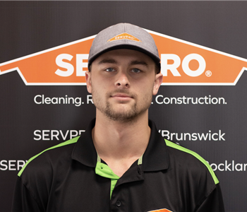 SERVPRO employee in front of logo
