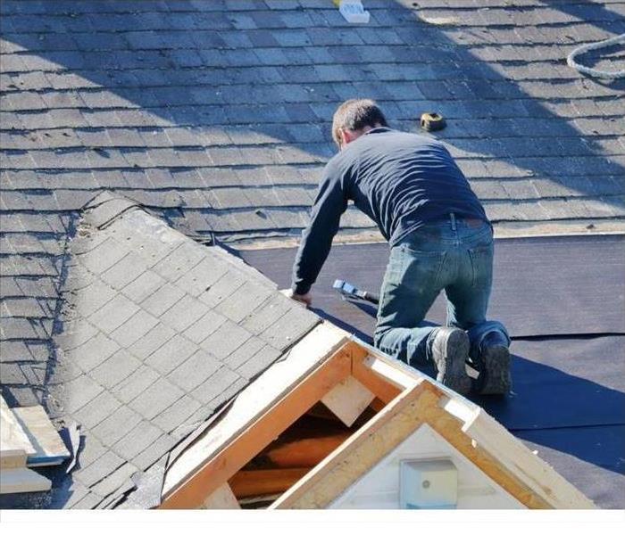 Man tarping a roof